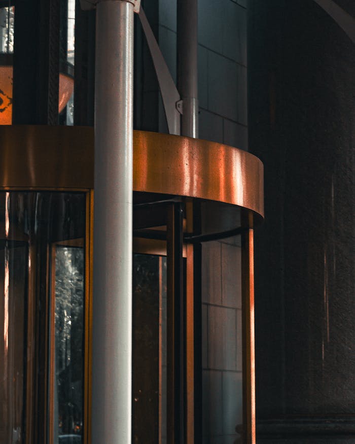 A modern building facade showcasing a sleek revolving door and metal accents, ideal for urban themes.